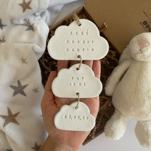 Load image into Gallery viewer, Three cloud-shaped decorative items with engraved text held by a hand, with a soft toy and blanket in the background.
